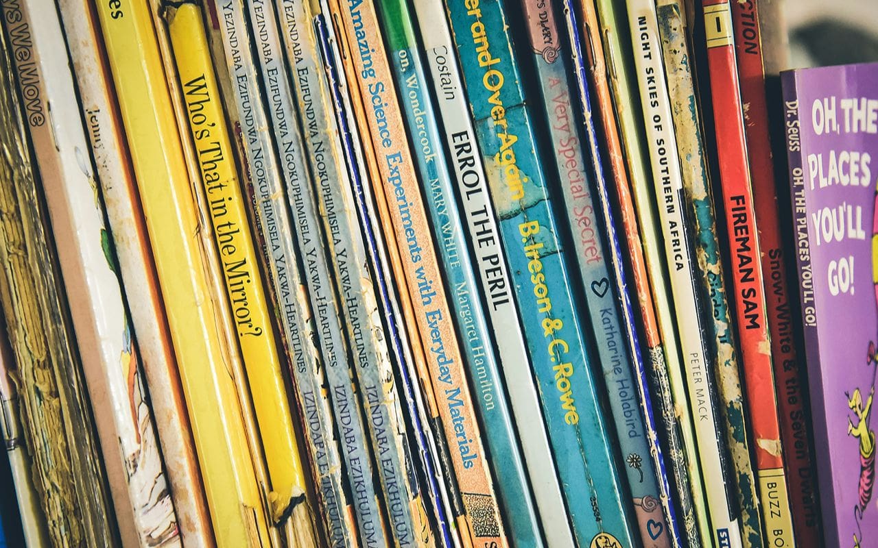 A close-up of vinyl record spines on a shelf.